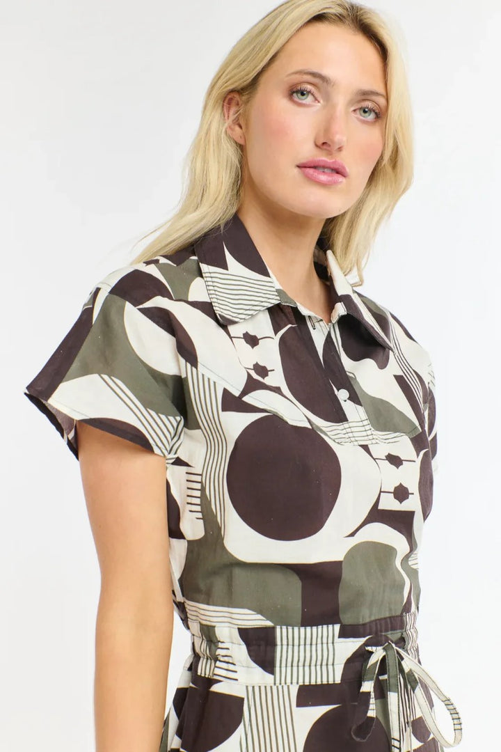 Woman wearing a patterned dress with abstract designs on a white background