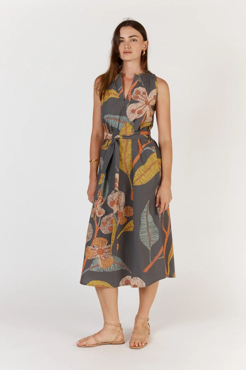 Woman wearing a sleeveless floral dress on a white background