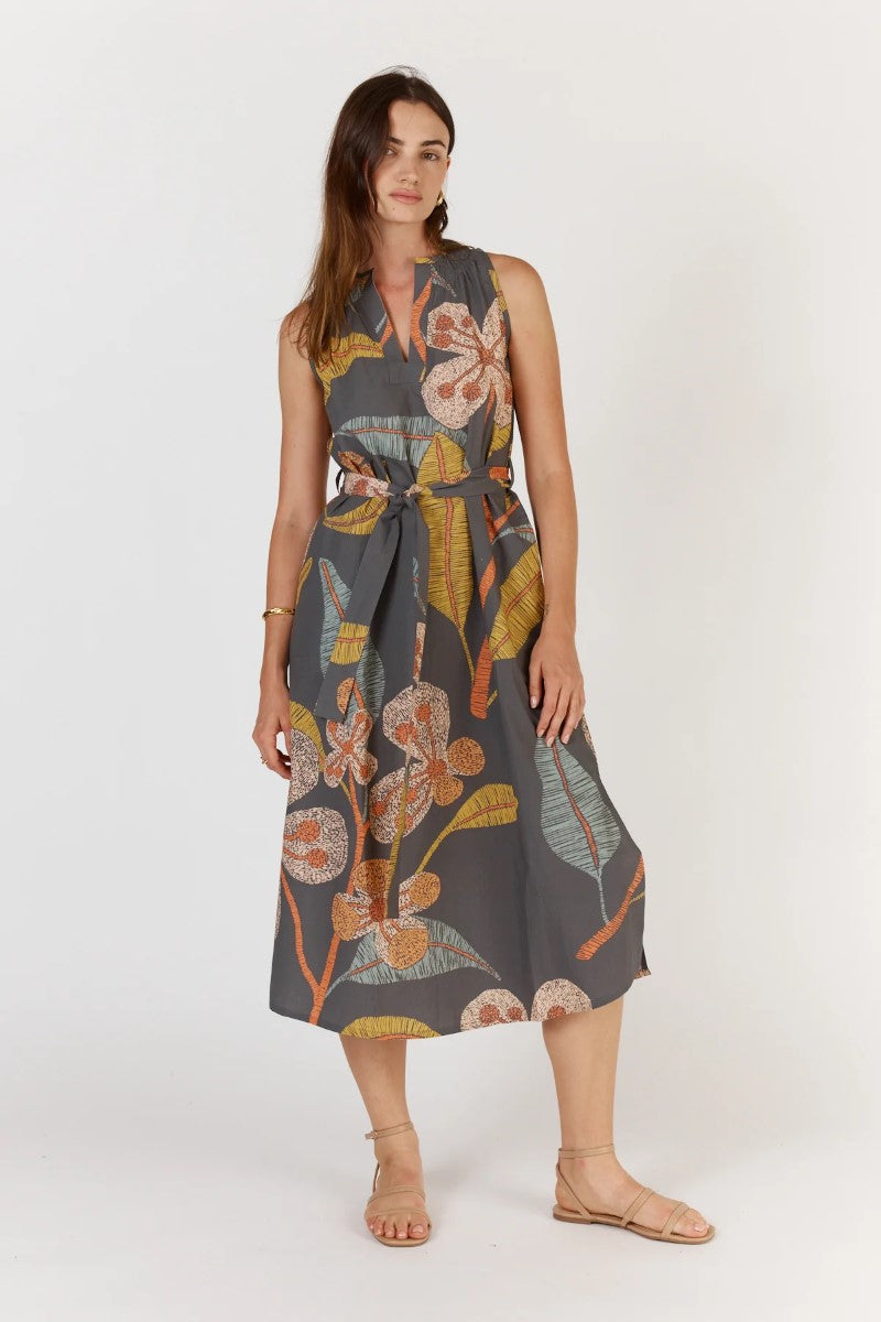 Woman wearing a sleeveless floral dress on a white background