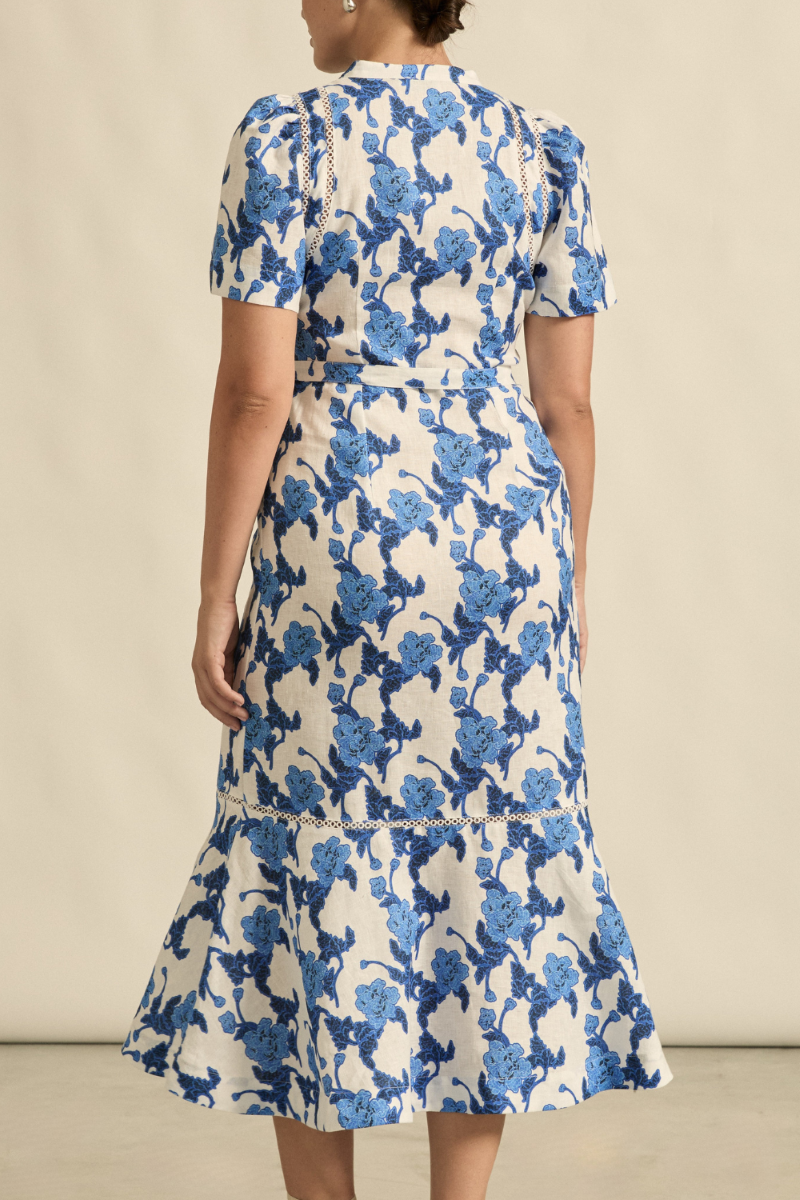 This back view of the Cable Dress in Azure Bouquet highlights its flowing A-line shape, self-tie belt, and subtle back detailing, creating an effortlessly elegant look.