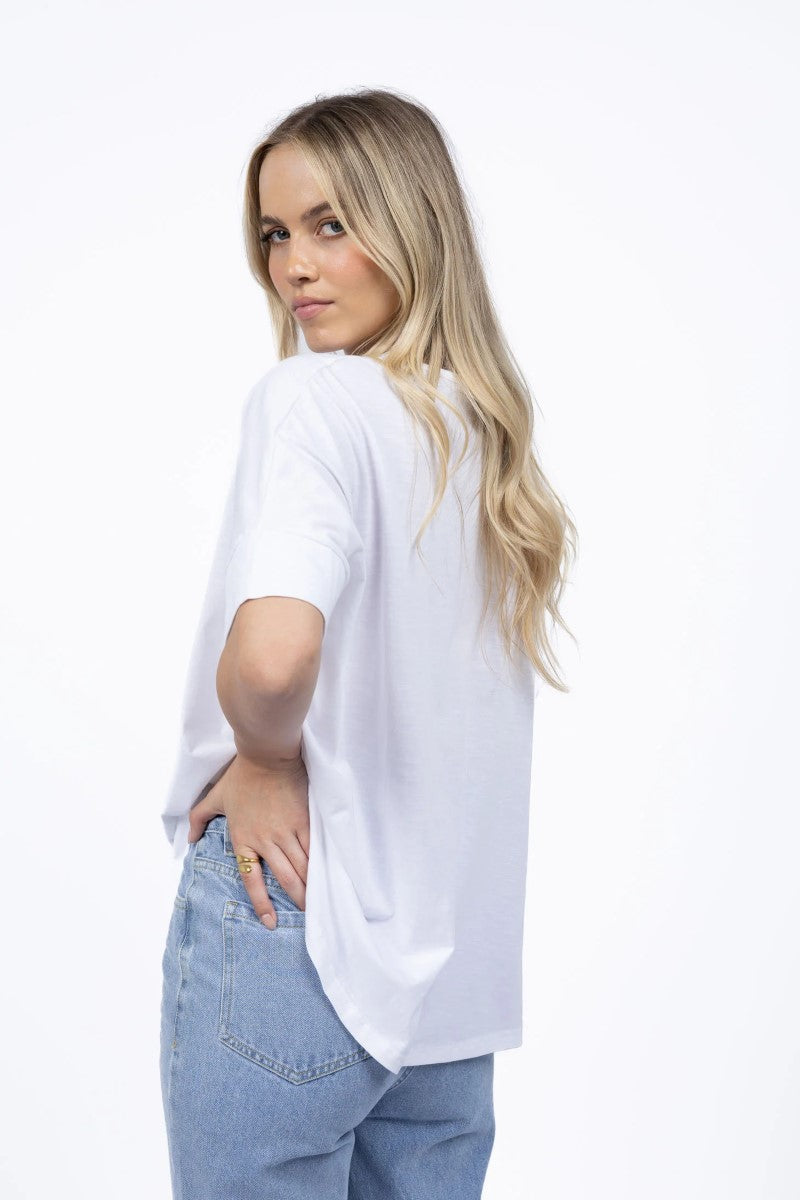 Woman wearing a white oversized shirt and light blue jeans on a white background