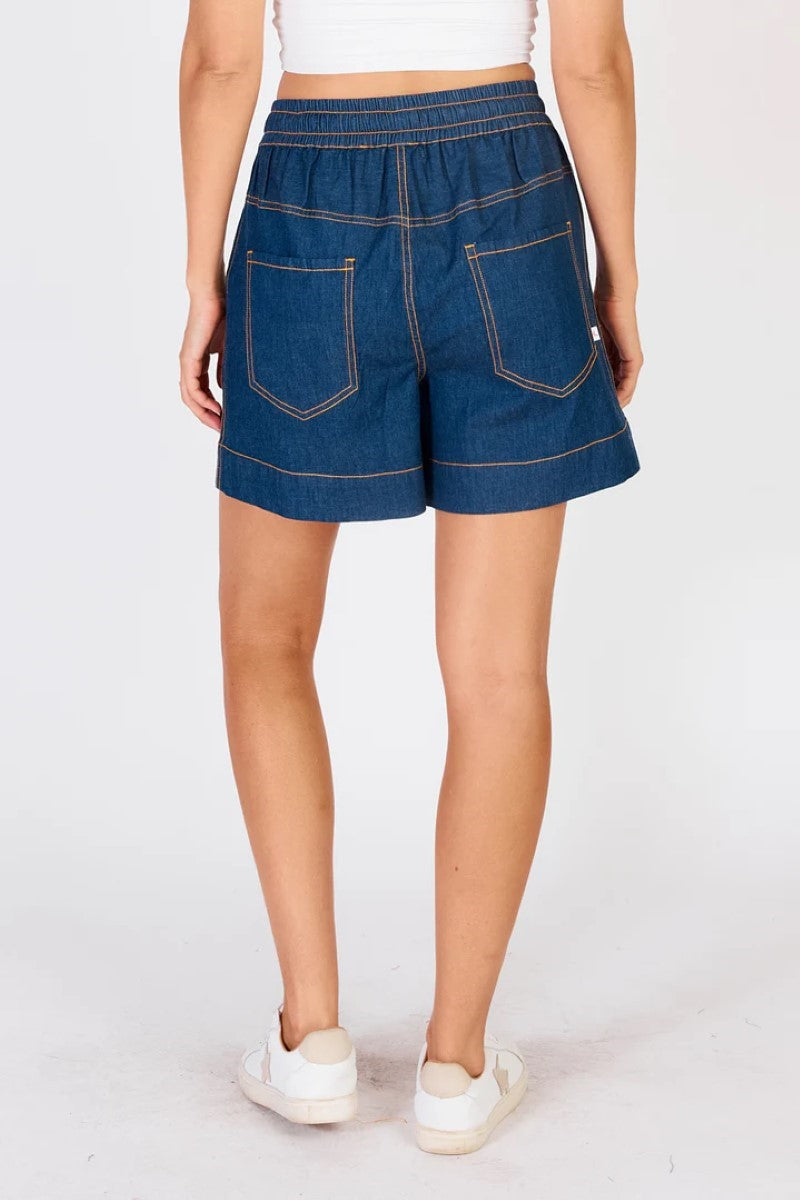 Person wearing blue denim shorts on a white background