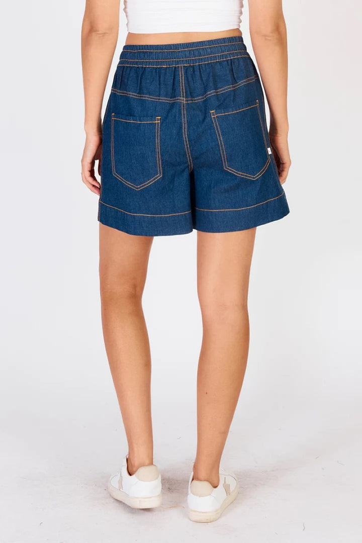 Person wearing blue denim shorts on a white background
