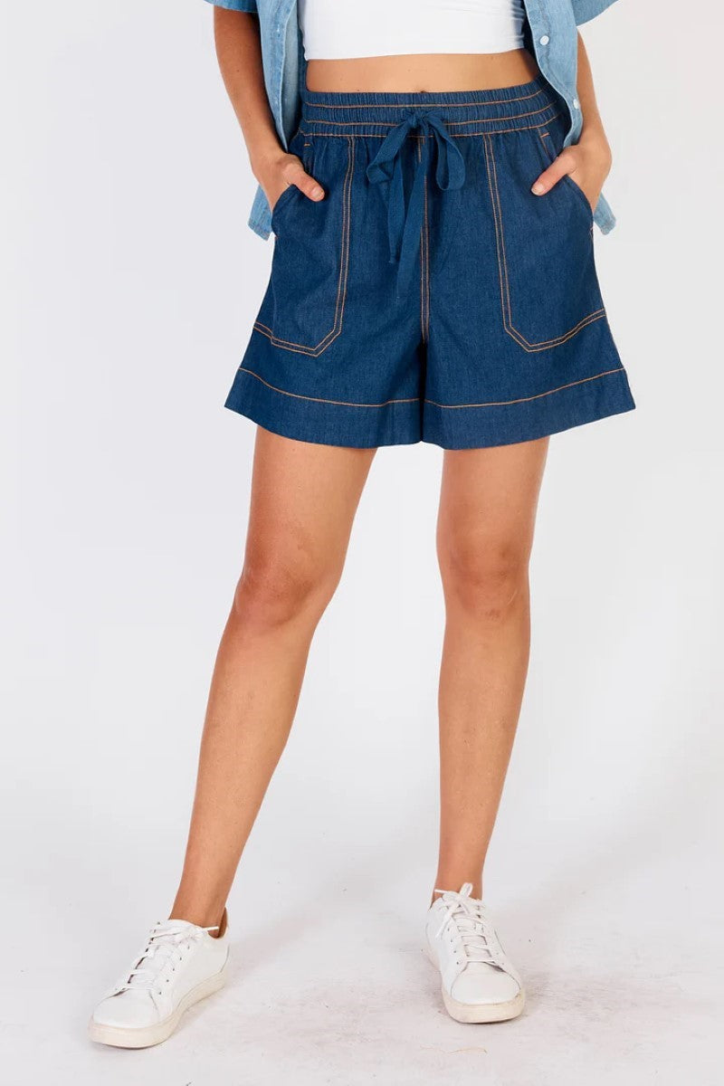 Person wearing blue denim shorts on a white background