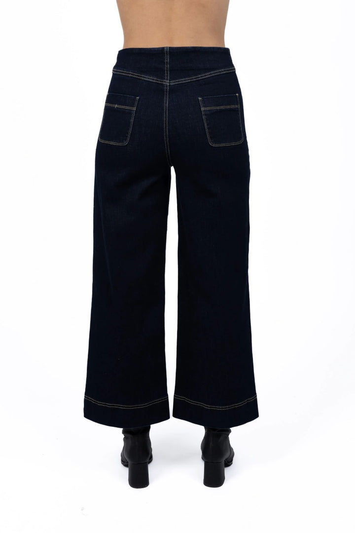 Back view of Fleetwood Jean in dark blue, displayed at Ivy Vibe Boutique, featuring classic back pockets and a flattering high-rise, straight-leg fit.