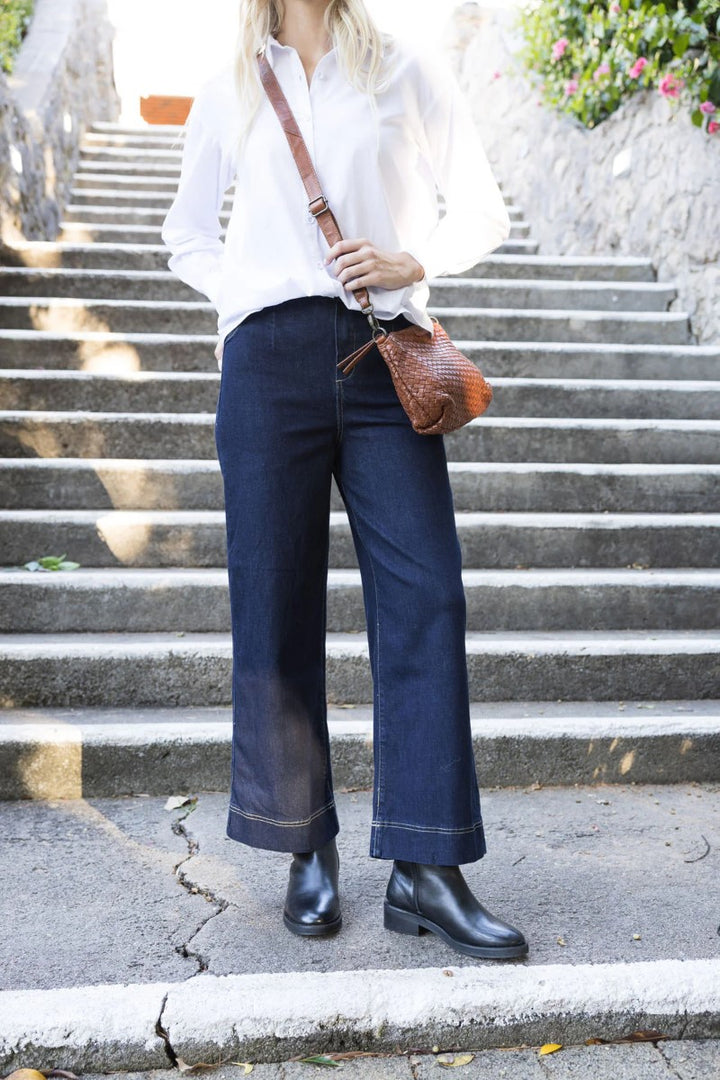 Lifestyle image of the Fleetwood Jean in dark blue, styled at Ivy Vibe Boutique, showcasing a flattering fit and classic denim look in a casual setting