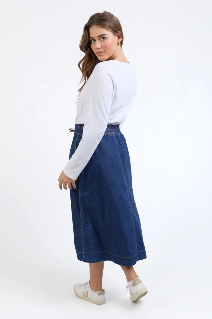 Side view of Greta Denim Skirt in dark blue, showcasing the high-waisted fit and sleek side profile, from Ivy Vibe Boutique.