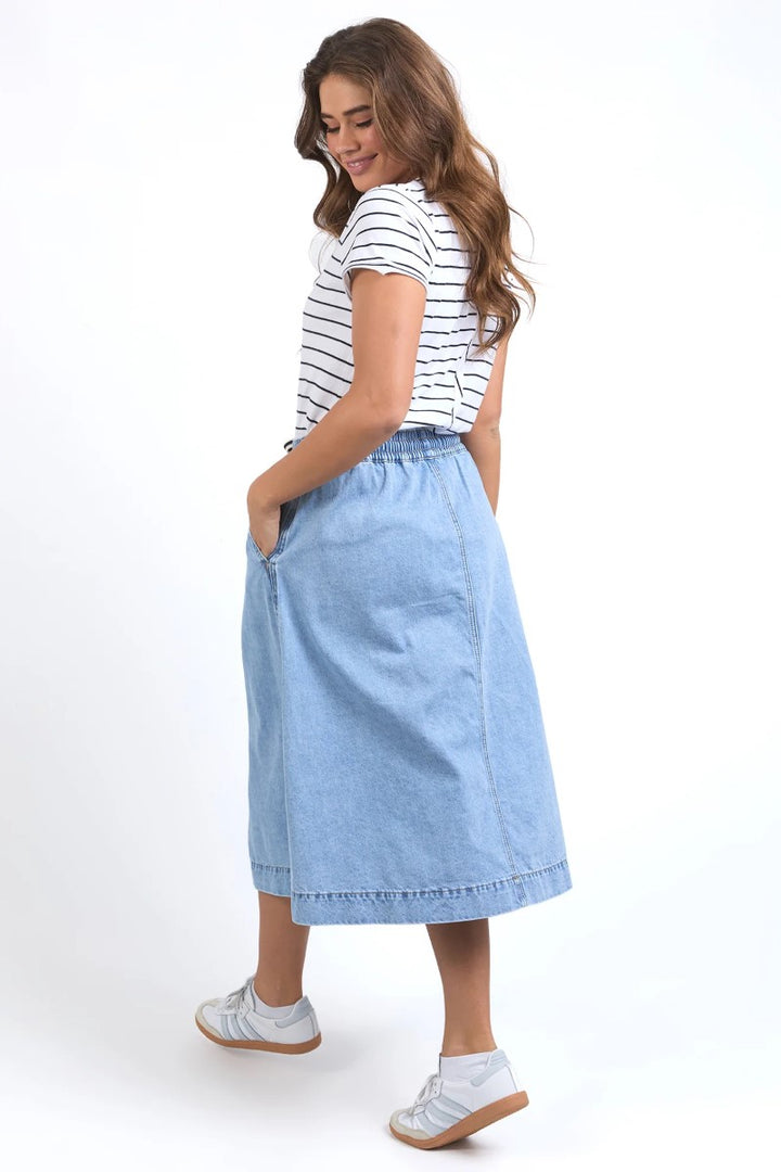 Side view of Greta Denim Skirt in light blue, featuring a flattering high-waisted fit and clean side seam, from Ivy Vibe Boutique.