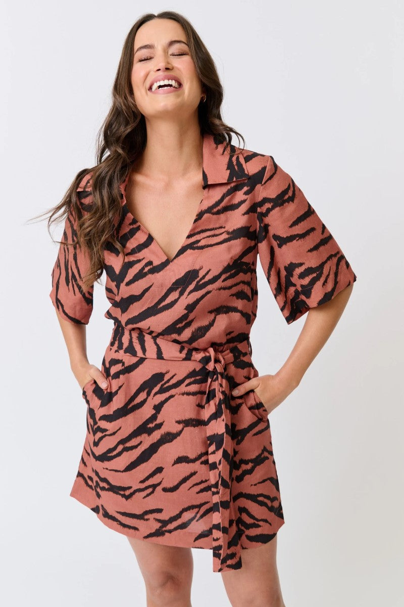 Woman wearing a pink and black tiger pattern dress on a white background