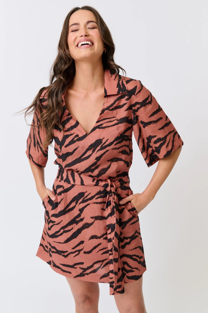 Woman wearing a pink and black tiger pattern dress on a white background