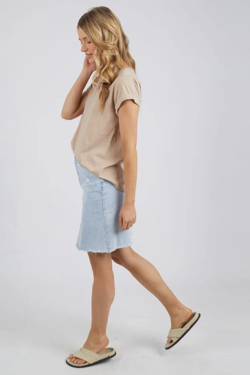 The Manly Vee Tee in Oatmeal is shown from the side, highlighting its relaxed fit, curved hem, and rolled sleeve cuff, made from soft 100% Pima Cotton — Ivy Vibe.