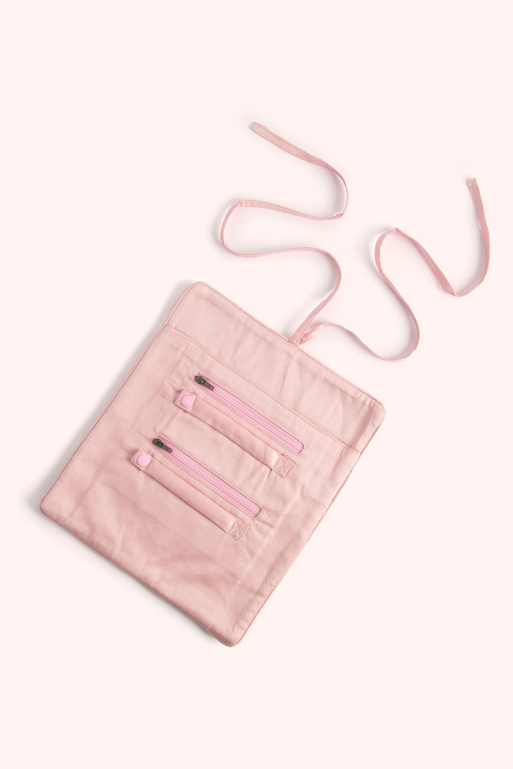 Pink crossbody bag with a strap on a white background