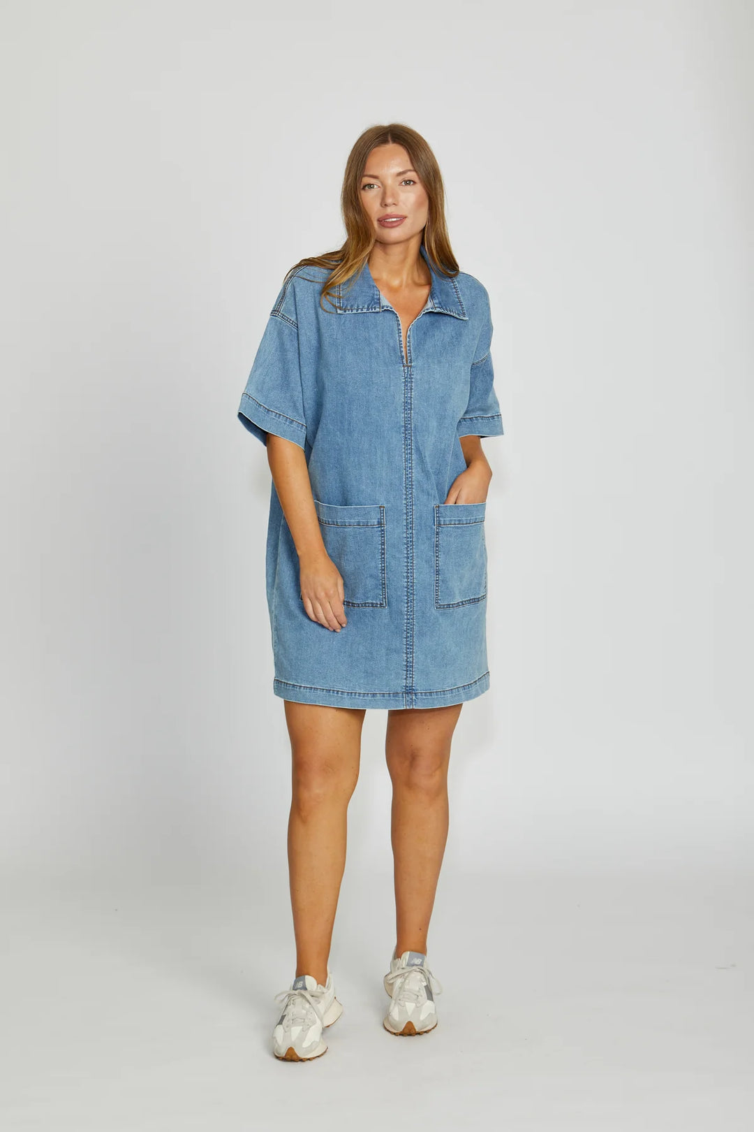Woman wearing a blue denim dress on a white background