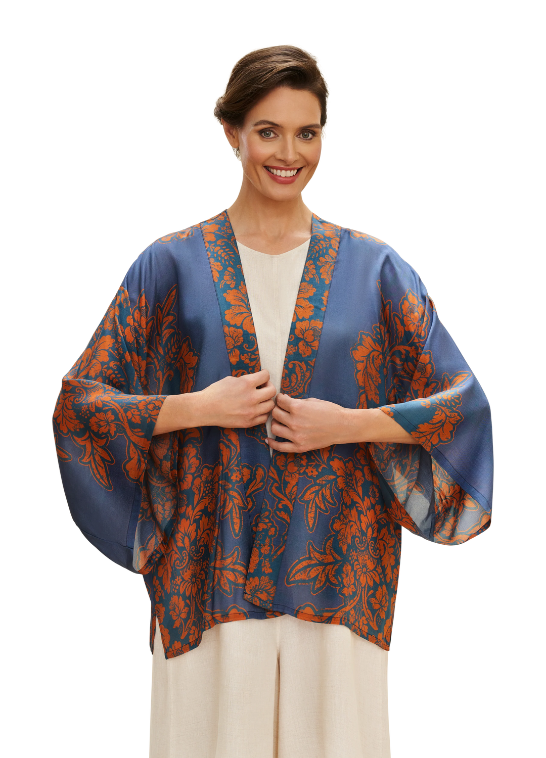 Woman wearing a blue and orange patterned kimono against a white background