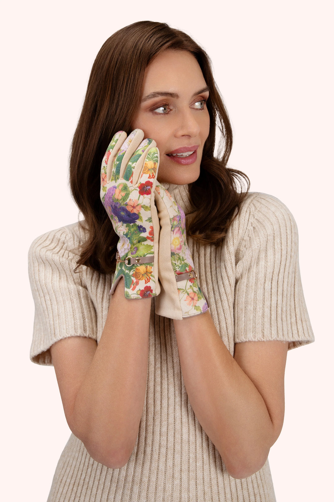 Woman wearing floral gardening gloves on a white background