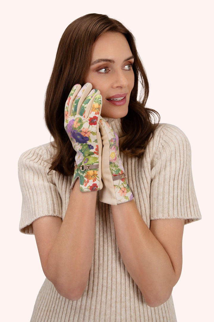 Woman wearing floral gardening gloves on a white background