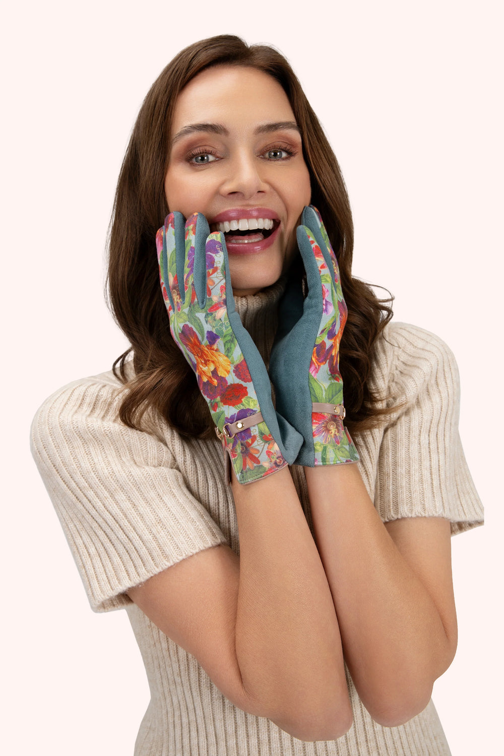 Woman wearing colorful floral gloves on a white background