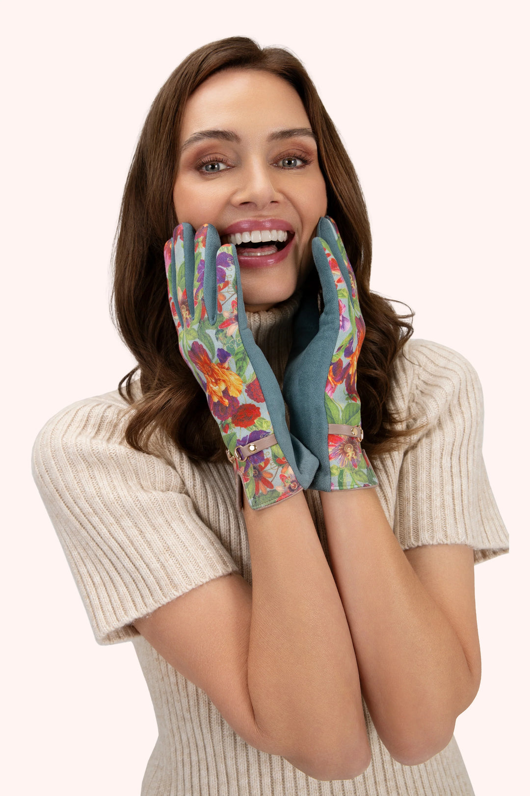 Woman wearing colorful floral gloves on a white background