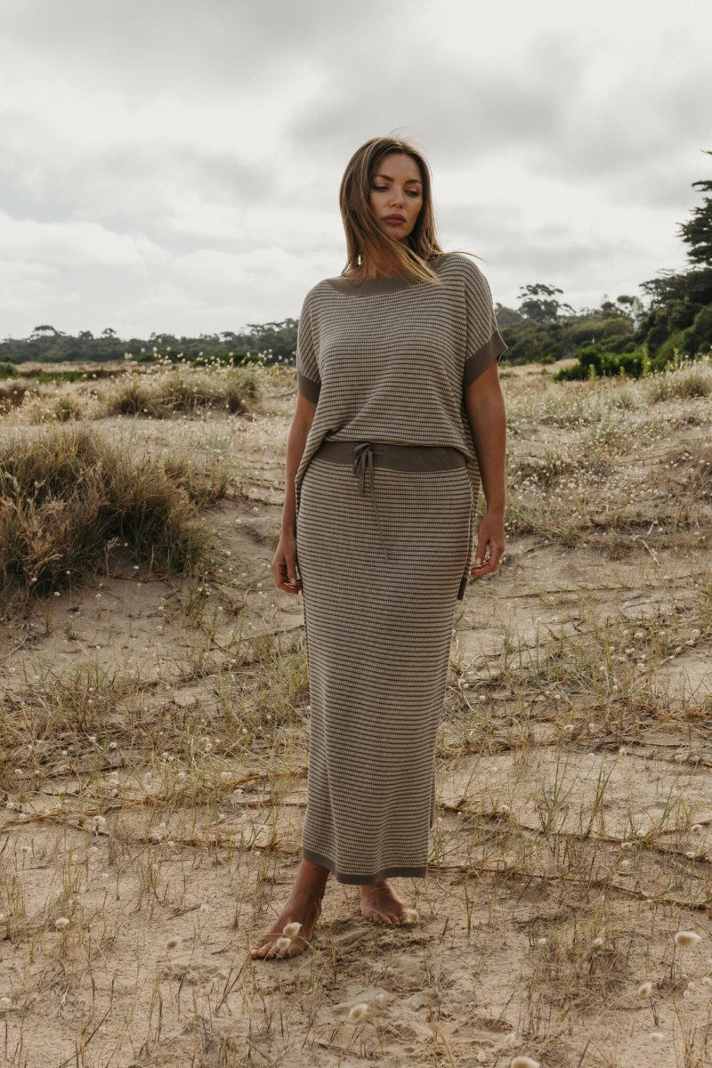 Woman wearing a matching top and skirt set in a natural setting