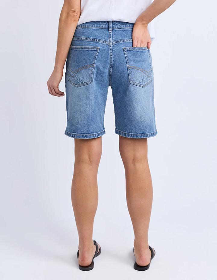 Denim shorts worn by a person on a white background