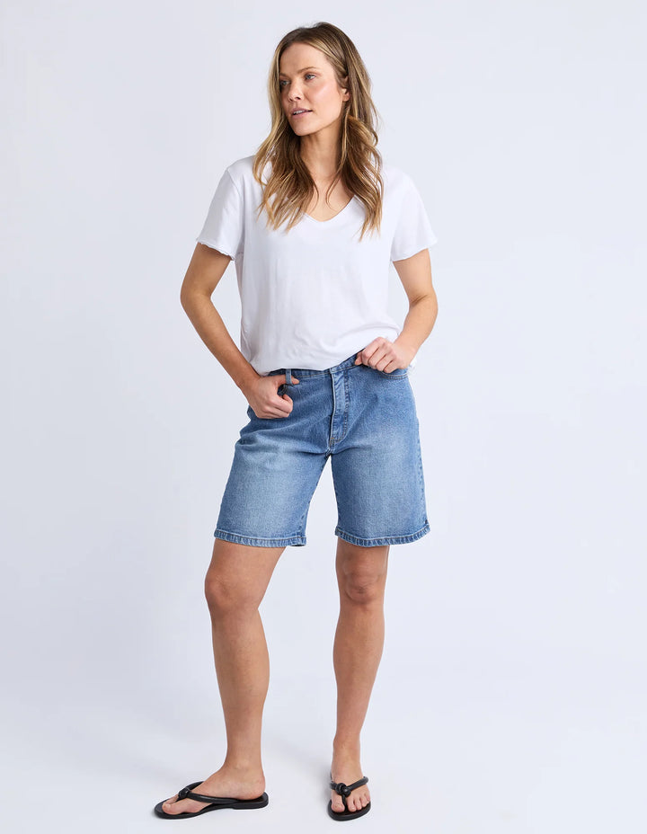 Woman wearing a white t-shirt and blue denim shorts on a white background