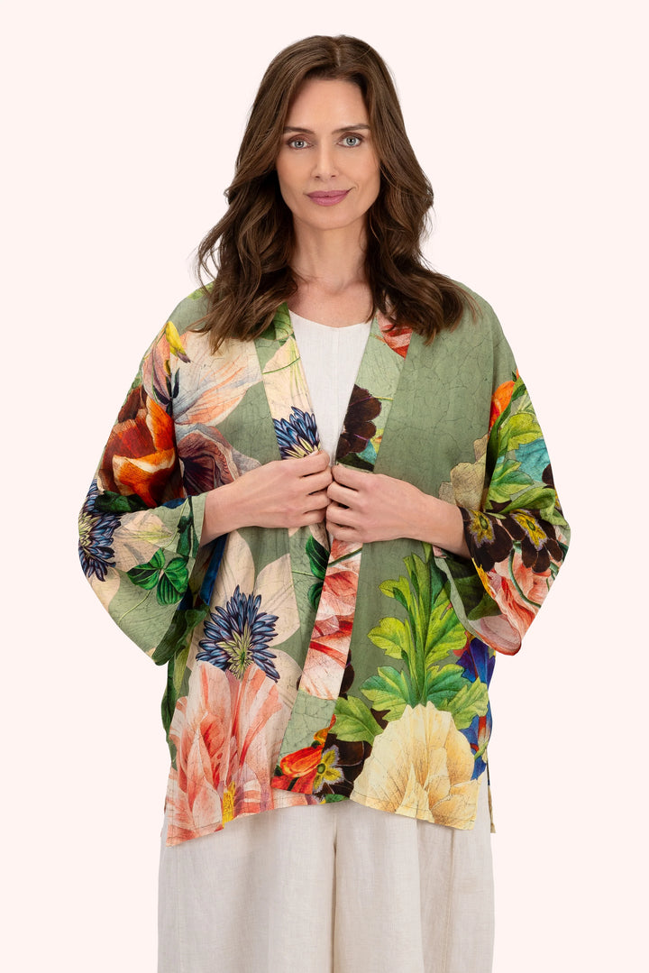 Woman wearing a colorful floral kimono against a white background