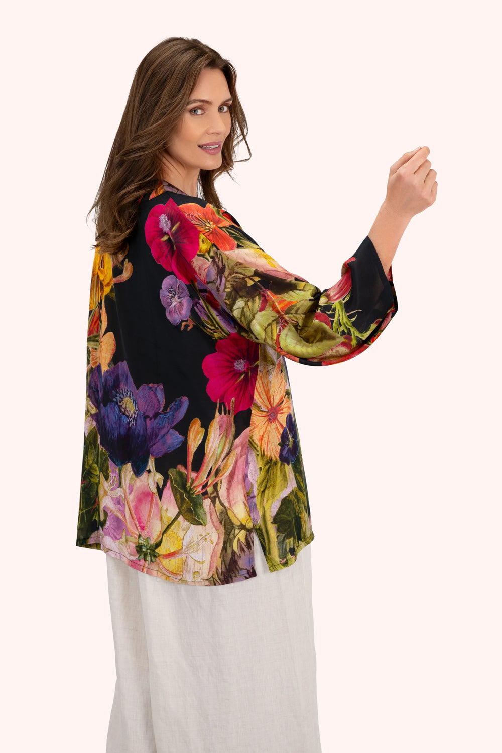 Woman wearing a colorful floral blouse with a white background