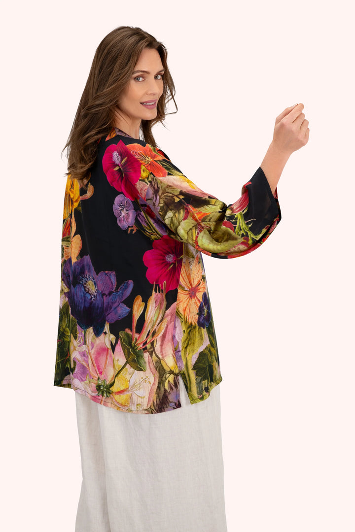 Woman wearing a colorful floral blouse with a white background