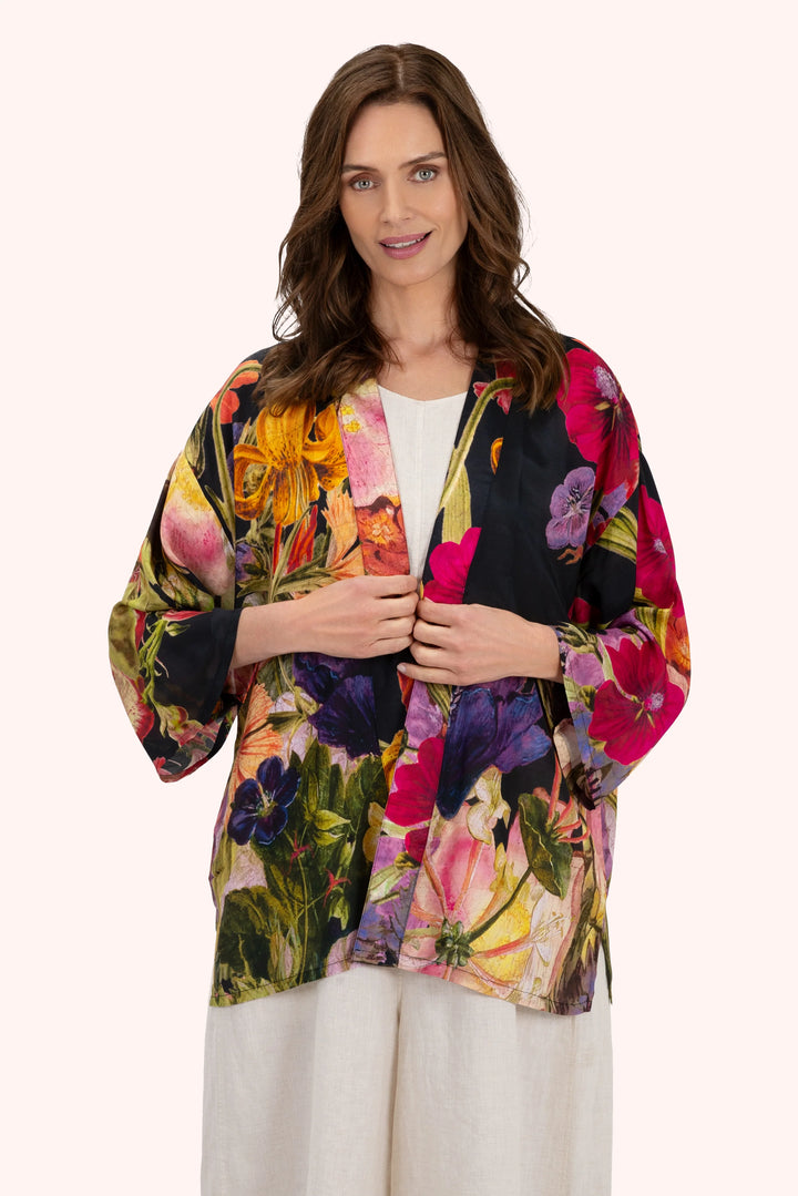 Woman wearing a colorful floral kimono-style jacket on a white background