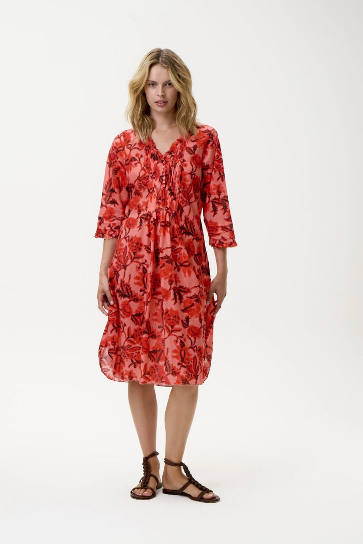 Woman wearing a red floral dress on a white background