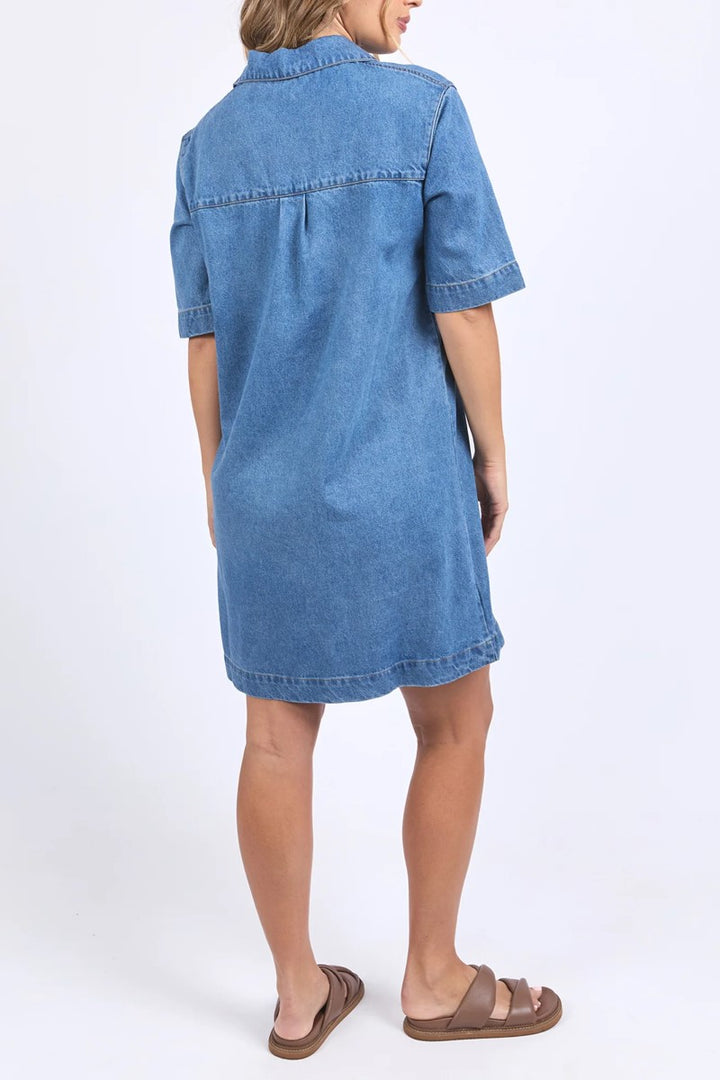 Blue denim dress worn by a person on a white background