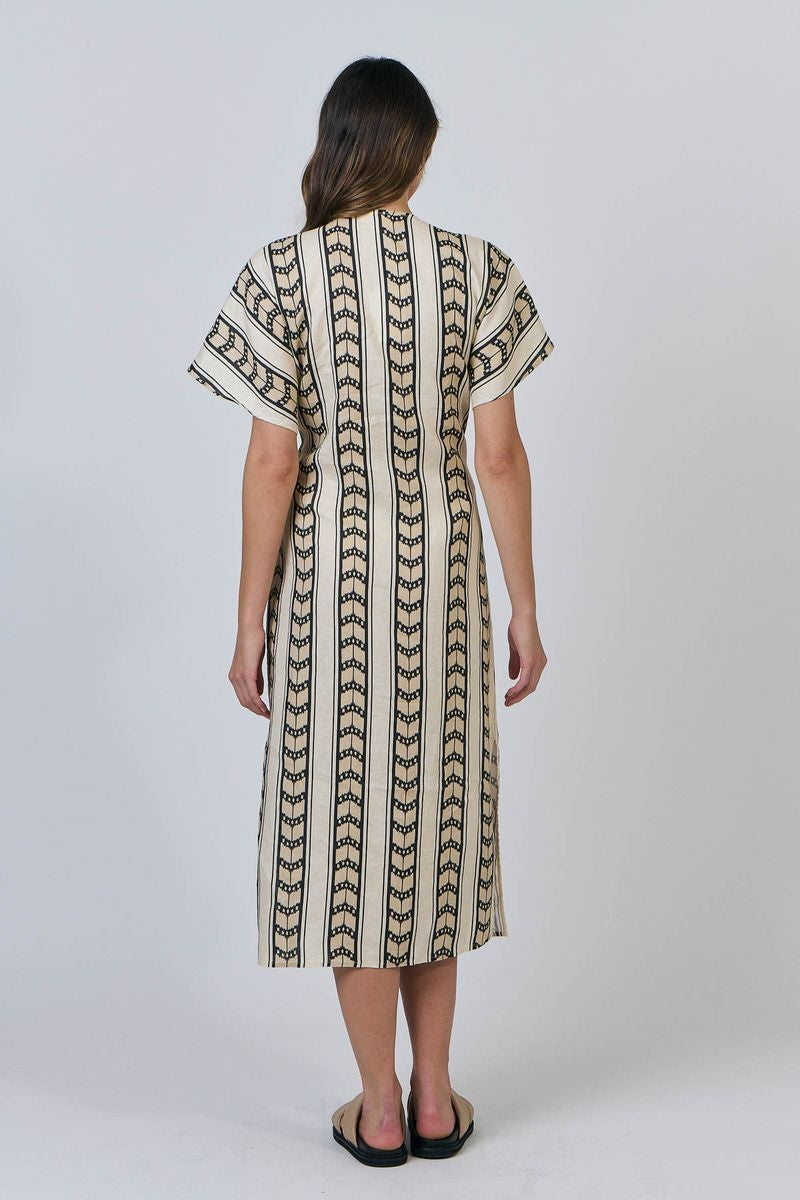 Woman wearing a patterned dress on a white background