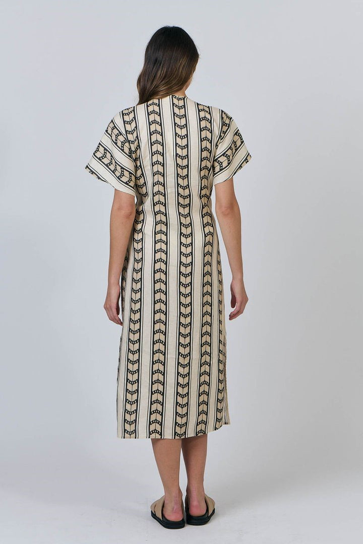 Woman wearing a patterned dress on a white background