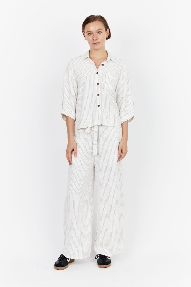 Model wearing the Carbon Nero Pant Set at Ivy Vibe, featuring matching striped linen top and pants with a relaxed fit and effortless, coordinated style.