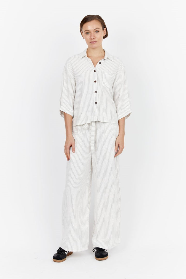 Model wearing the Carbon Nero Pant Set at Ivy Vibe, featuring matching striped linen top and pants with a relaxed fit and effortless, coordinated style.