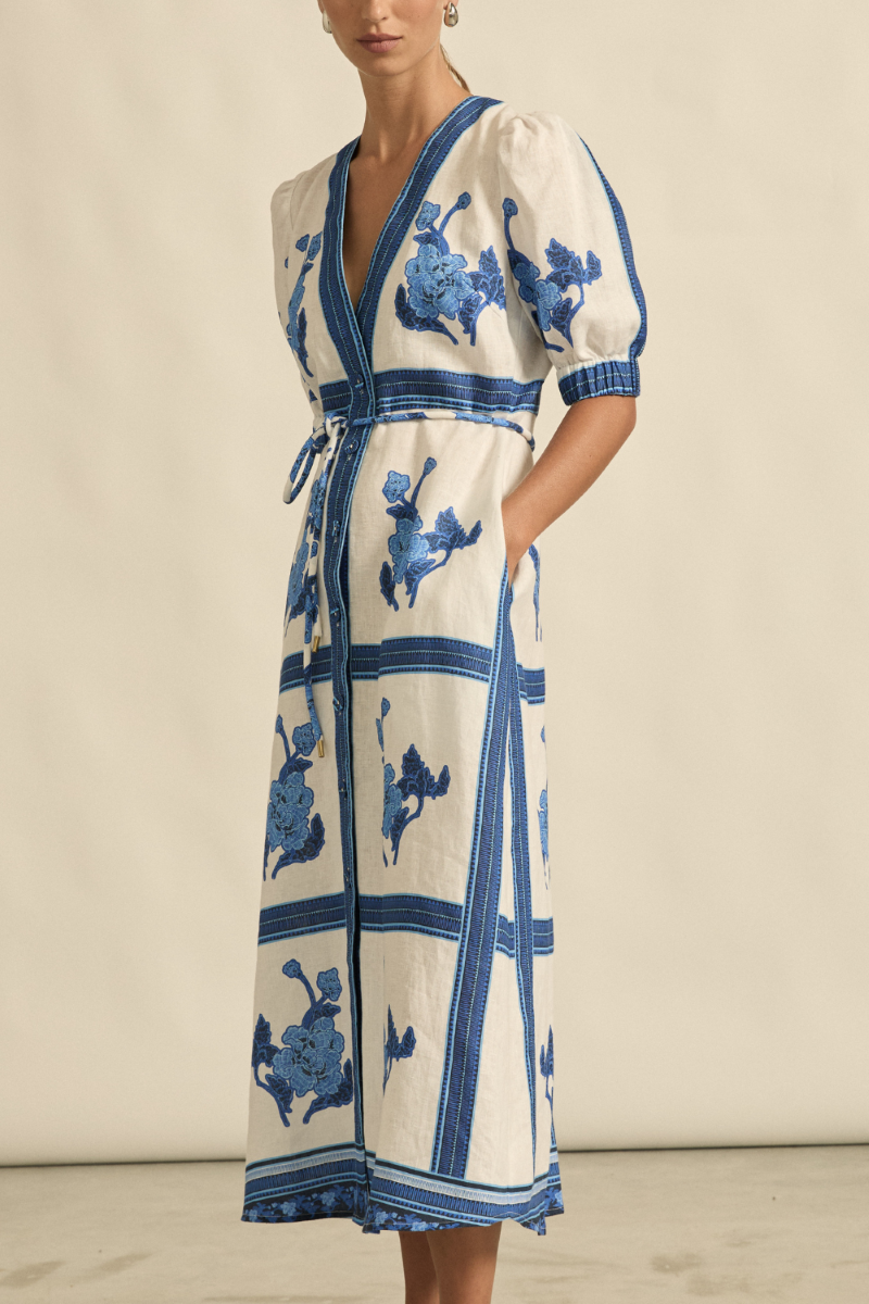 This side view of the Portrait Dress in Azure Collage highlights its flattering A-line silhouette, softly gathered blouson sleeve, and the elegant drape of the 100% linen fabric.