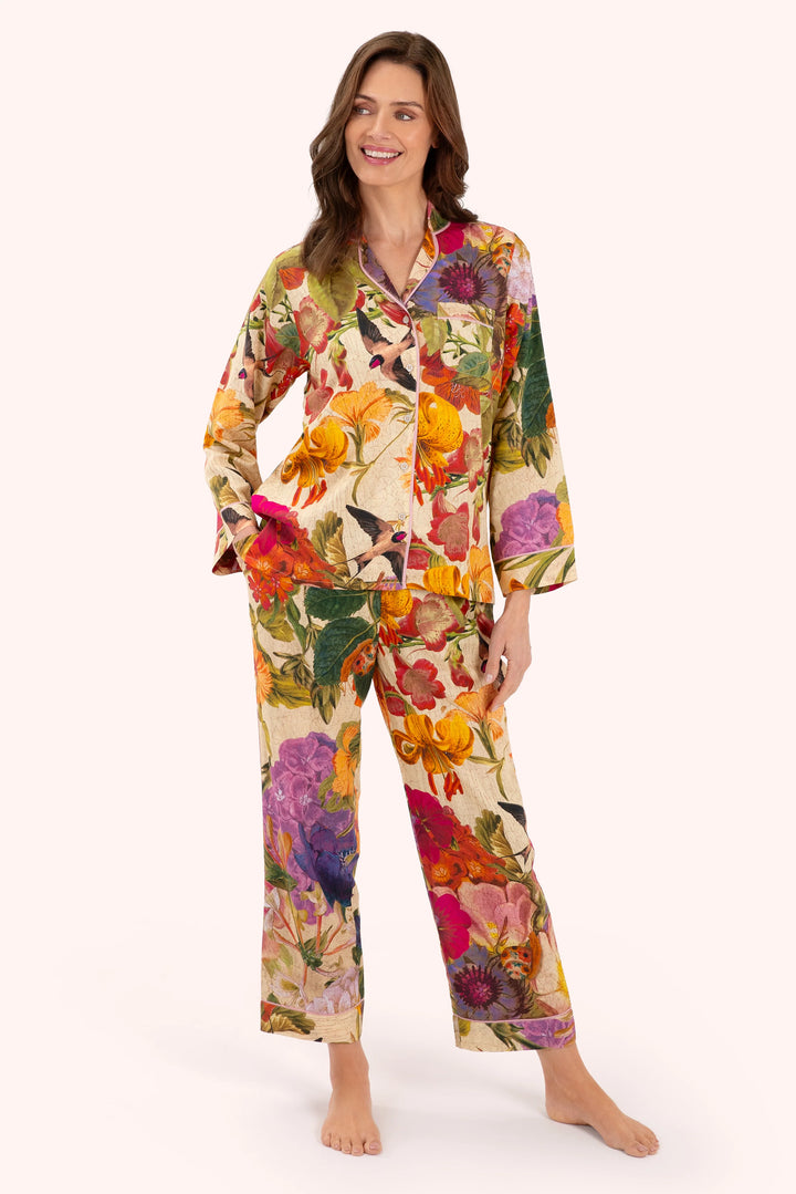 Woman wearing a colorful floral pajama set on a white background