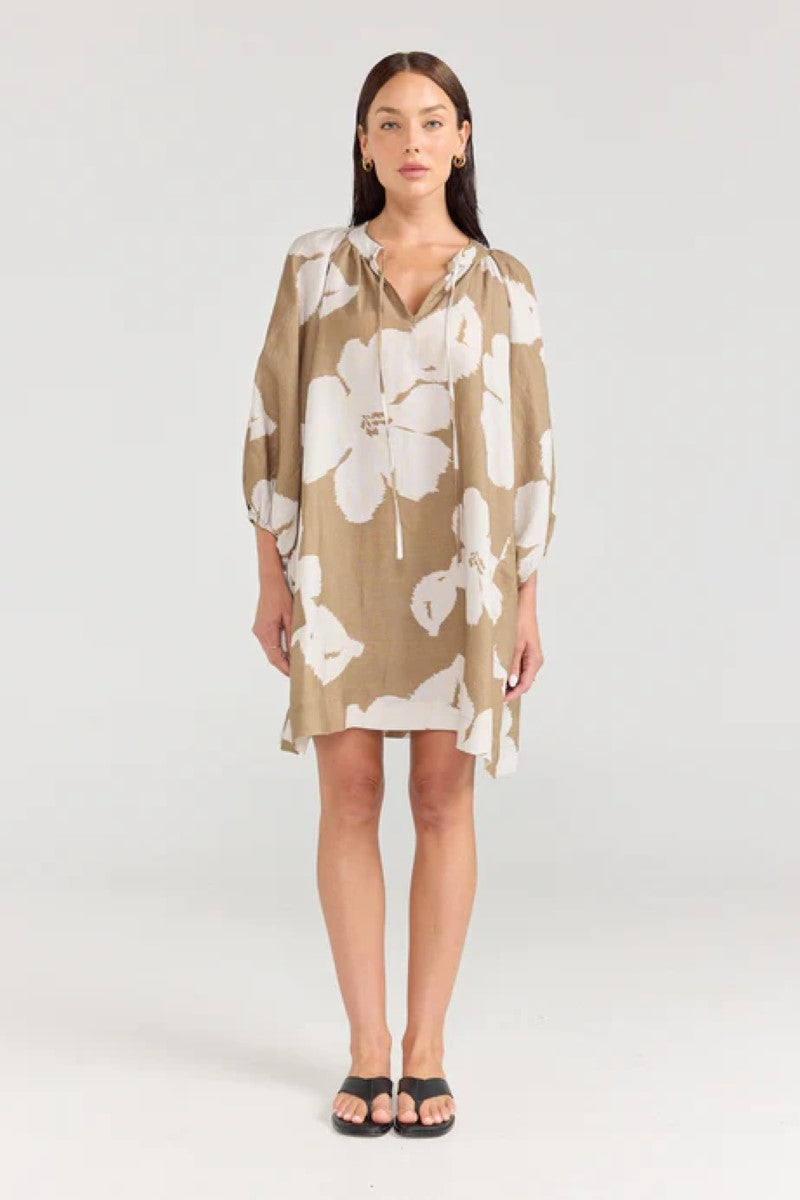 Woman wearing a beige floral dress on a white background