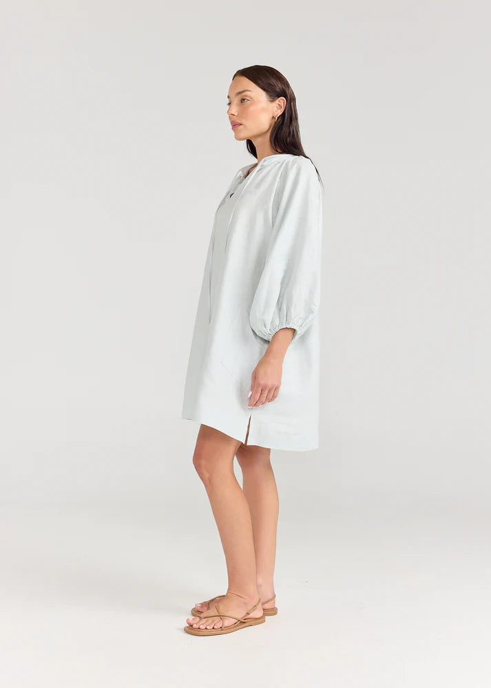 Woman wearing a light green dress on a white background