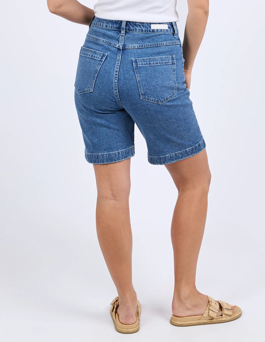 Person wearing blue denim shorts on a white background