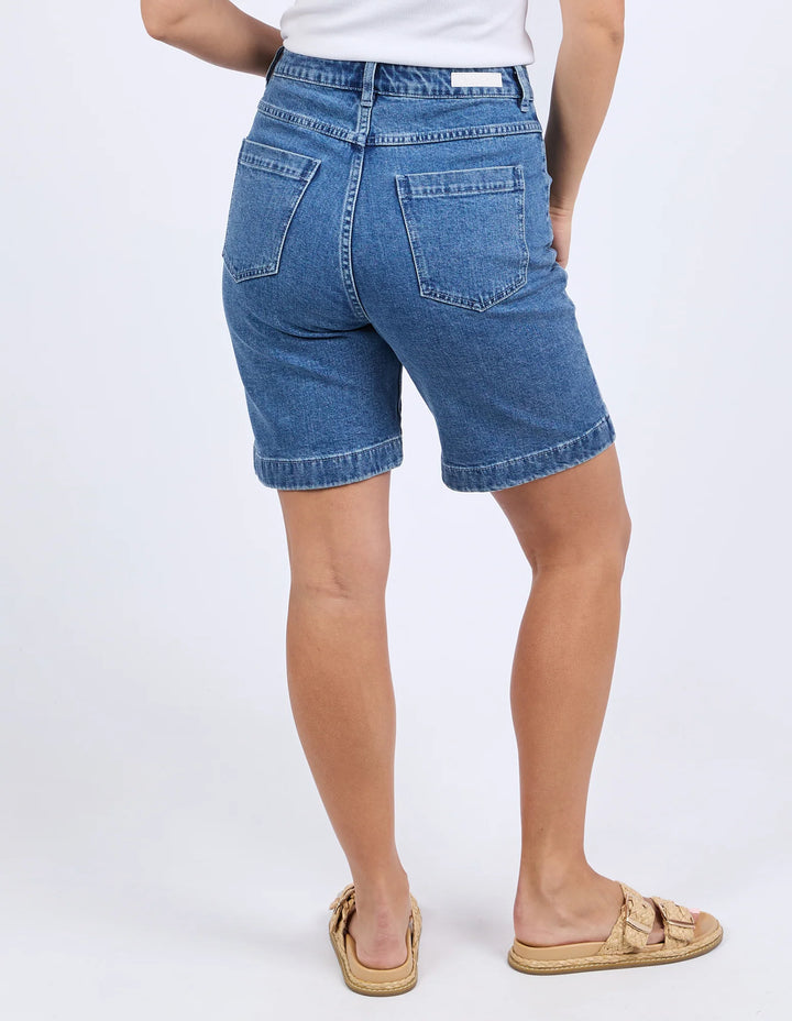 Person wearing blue denim shorts on a white background