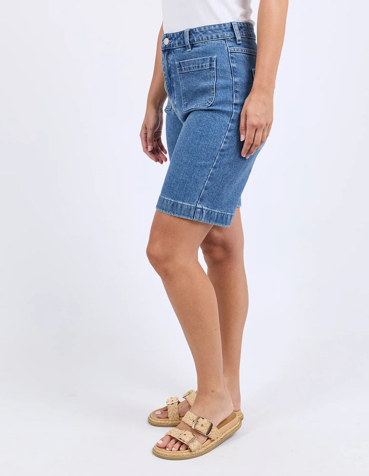 Denim shorts worn by a person on a white background