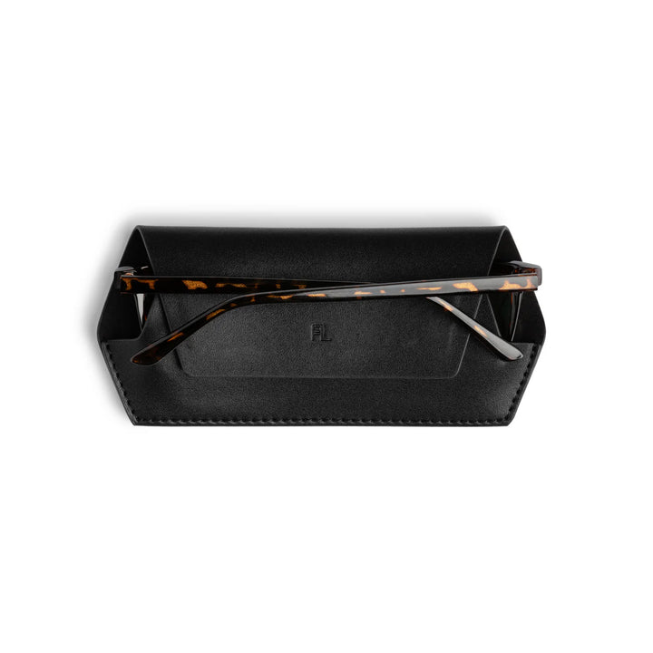 Black glasses case with tortoiseshell-framed glasses on a white background