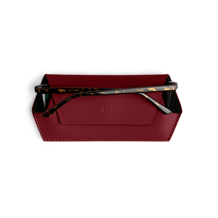 Red clutch with tortoiseshell sunglasses on a white background