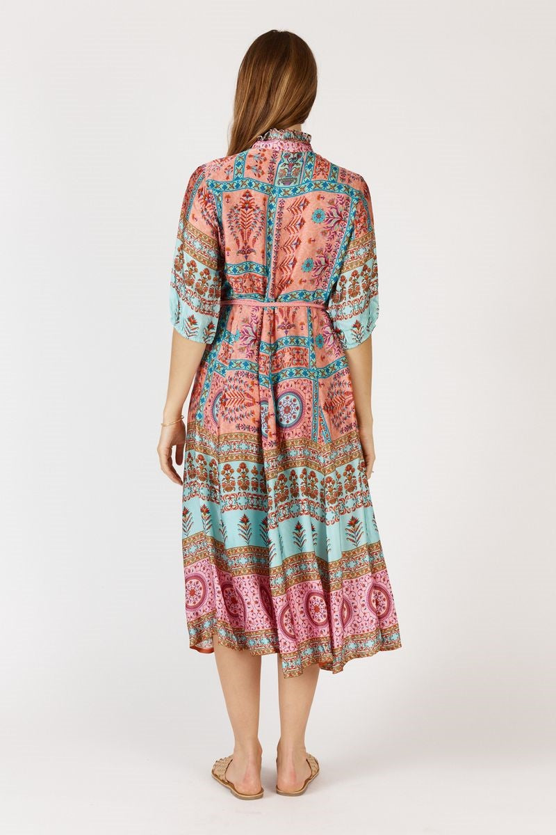 Woman wearing a colorful patterned dress on a white background