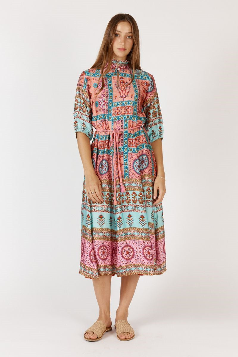 Woman wearing a patterned dress on a white background