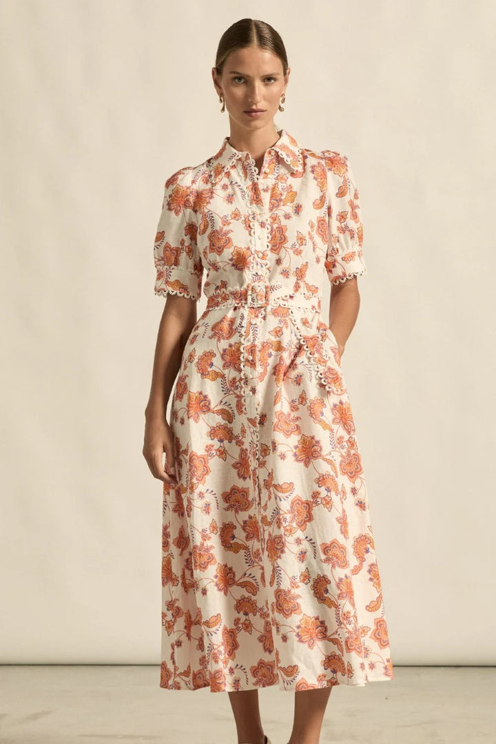 Woman wearing a floral dress against a neutral background