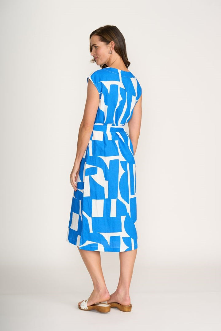 Woman wearing a blue and white patterned dress on a plain background