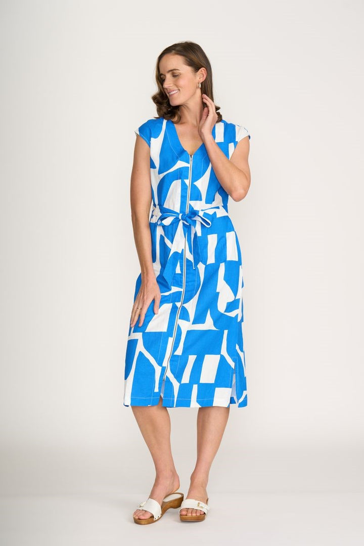 Woman wearing a blue and white patterned dress on a plain background