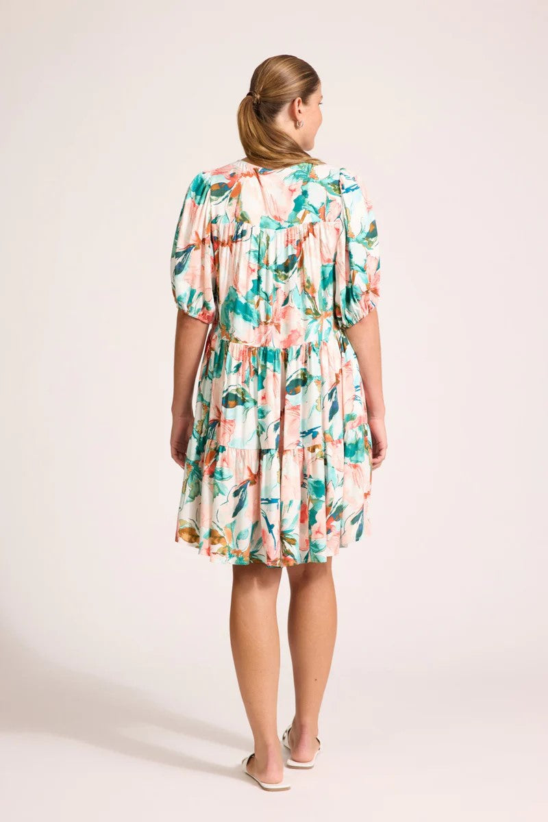Woman wearing a floral dress on a plain background